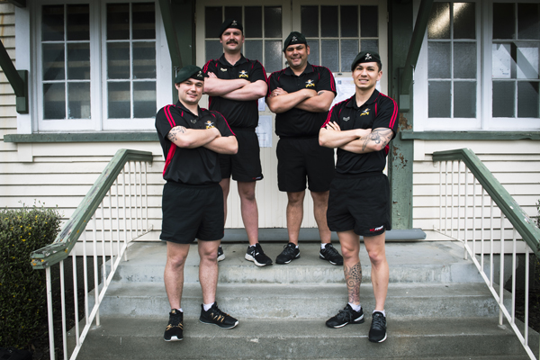 Four NZDF members standing together on steps outside a building