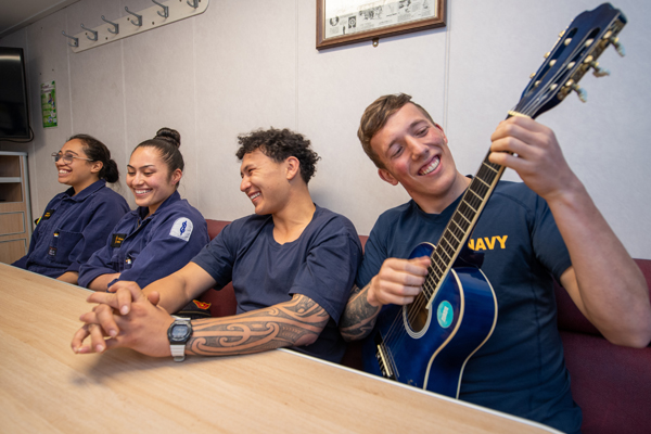 Navy personnel playing a guitar and singing