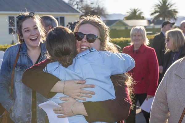 Members of the NZDF community hugging and smiling