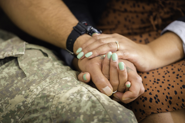 A Defence Force member holding hands with their partner