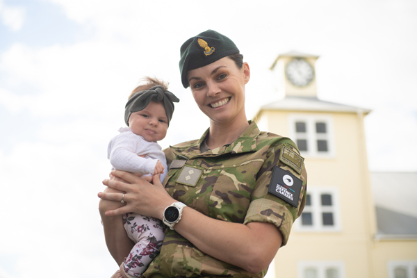 NZDF member holding her baby and smiling